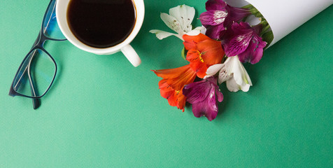  White cup with coffee in orchid flowers on a green background