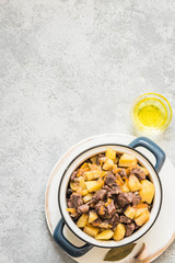 Slow cooker beef potato stew in a pot on concrete background. Top view, space for text.