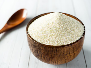 Semolina in a wooden bowl on a light background