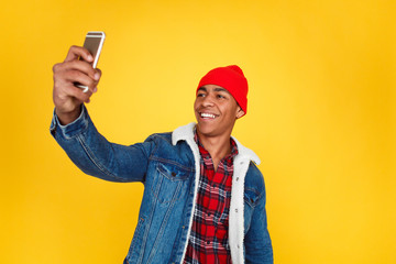 Stylish guy taking selfie on yellow