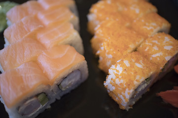 delicious sushi roll with salmon raw shrimp eggs and sesame with seaweed, wasabi on black dish for lunch or dinner at japanese food restaurant.