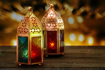 Two colorful oriental Lamp lanterns burn with candles with colorful bokeh background for Ramadan and other islamic muslim holidays, space for text