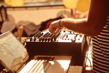 DJ behind remote control works adjust sound