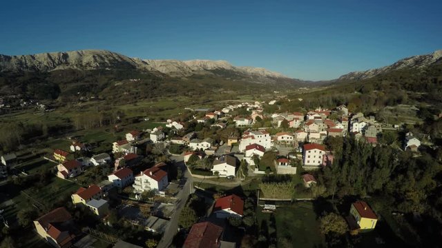 Houses and mountains of Baska town, aerial