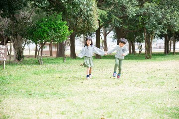 Fototapeta premium 手を繋いで歩く笑顔の子供