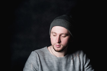 Portrait the man in black shirt and black baseball cap on the dark background