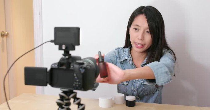 Woman taking video of showing the cosmetic product at home