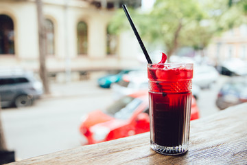 Clode-up view of wineglass wit fruit cocktail on the table, at cafe, outdoors.