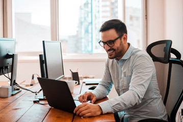 Young entrepreneur freelancer using a laptop in coworking space.