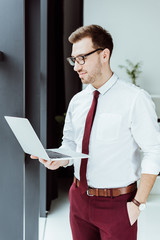 stylish businessman using laptop in modern office