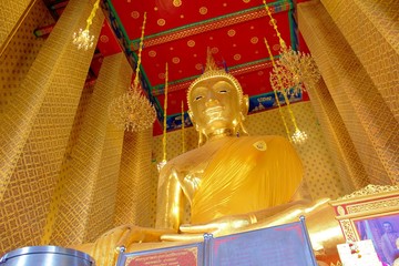 Big Buddha statue in gold color Golden wall with red ceiling