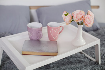 breakfast table in the bed.
cup of tea in the morning in bed.
pink cup with a heart
