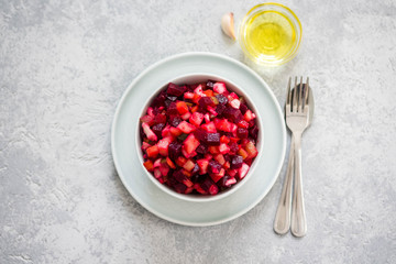 Beetroot salad in a bowl on light concrete background. Top view, copy space.