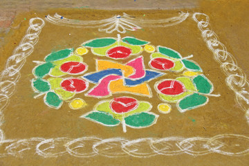 A colored mandala is painted on sand or on the ground. India, the village of Hampi