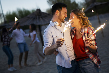 Picture of happy couple holding burning sparkle