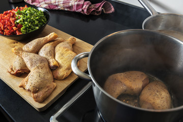 chicken being fried in a pot to cook it