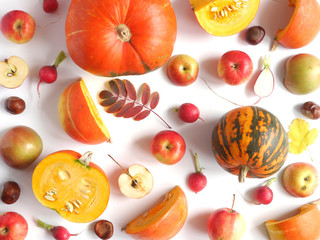 Autumn concept. Pumpkin, autumn leaves, persimmon,radish, chestnuts, red and green apples on a white background. Pattern of fresh vegetables. Top view, flat layout.