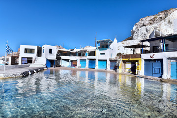 Obraz premium Fisherman houses built into rock cliffs on Mediterranean Sea, Firopotamos fishing village, Milos Island, Greece