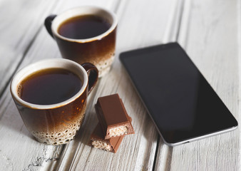 Two coffee mugs and a chocolate bar