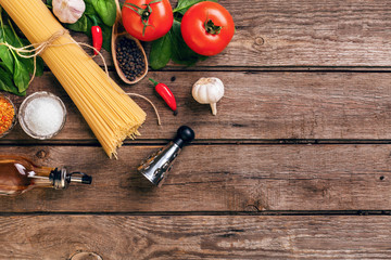 Pasta and ingredients on wooden background with copy space. Top view. Vegetarian food, healthy or cooking concept.