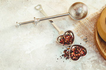 Metal tea infuser with leaves. Composition with tea accessories on a white background