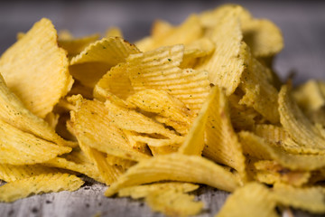 A lot of chips lie on the table, not a healthy diet and harmful food
