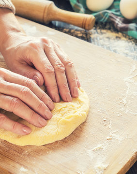 Woman kneading a dough on a table