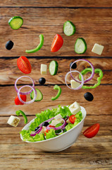 Greek Salad with flying ingredients to prepare it