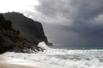 Obraz premium Big waves crushing on curved stone, on stormy weather, big tide. Alanya, Turkey.