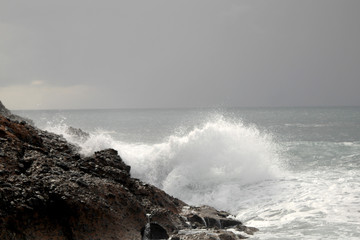 Big waves crushing on curved stone, on stormy weather, big tide. Alanya, Turkey.