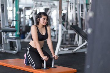 Fototapeta na wymiar Asian woman doing workout with gym equipment and wearing sportswear to lose weight.