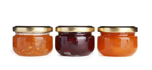 Three jars with tasty sweet jam on white background