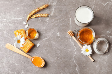 Beautiful composition with milk and honey on grey background