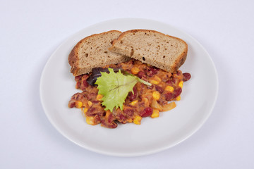 Cowboy beans with bread on a white