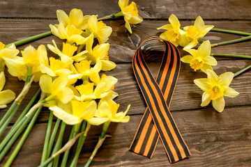 Daffodils and St. George ribbon on wooden background/St. George ribbon - the symbol of the great...