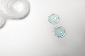 Contact lenses on light background, top view