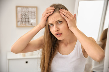 Young woman with hair loss problem indoors