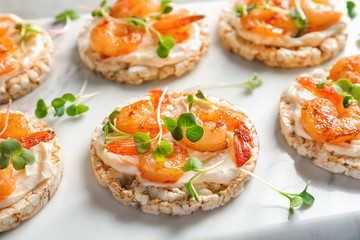 Delicious small sandwiches with shrimps on marble board