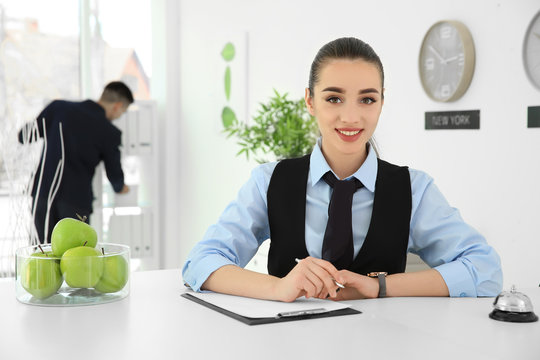 Busy female receptionist at workplace in hotel