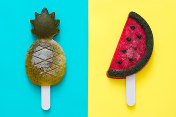 Pineapple and watermelon popsicles on blue and yellow background. Top view

