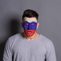 Young man with Russian flag painted on his face