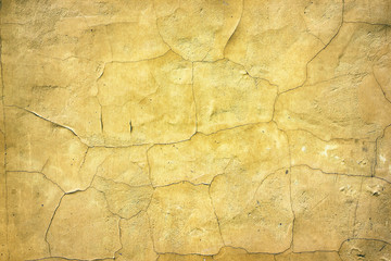 Retro background of aged yellow cracked concrete surface
