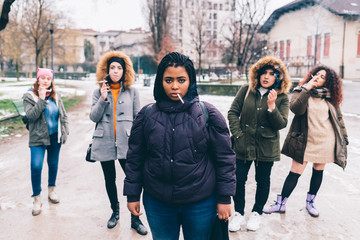 Portrait of young women smoking cigarettes on street