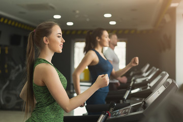 Fototapeta na wymiar Fitness people training in gym on treadmills