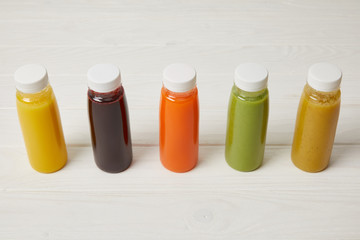 fresh organic smoothies in bottles standing in row on white