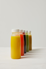 fresh detox smoothies in bottles standing in row on white