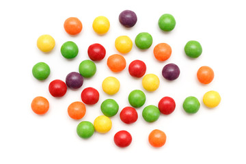 Colorful sweet candy pills spilled on white background