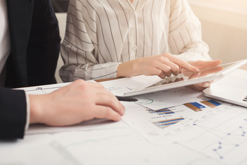 Business colleagues using tablet and working with documents