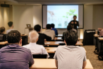 Audience listening speaker who standing in front of the room at the conference hall, Business and Entrepreneurship concept.