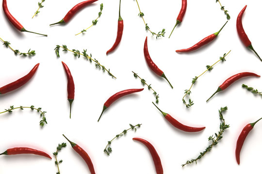 Red hot little chili peppers and green thyme pattern on white background. Top view. Flat lay.